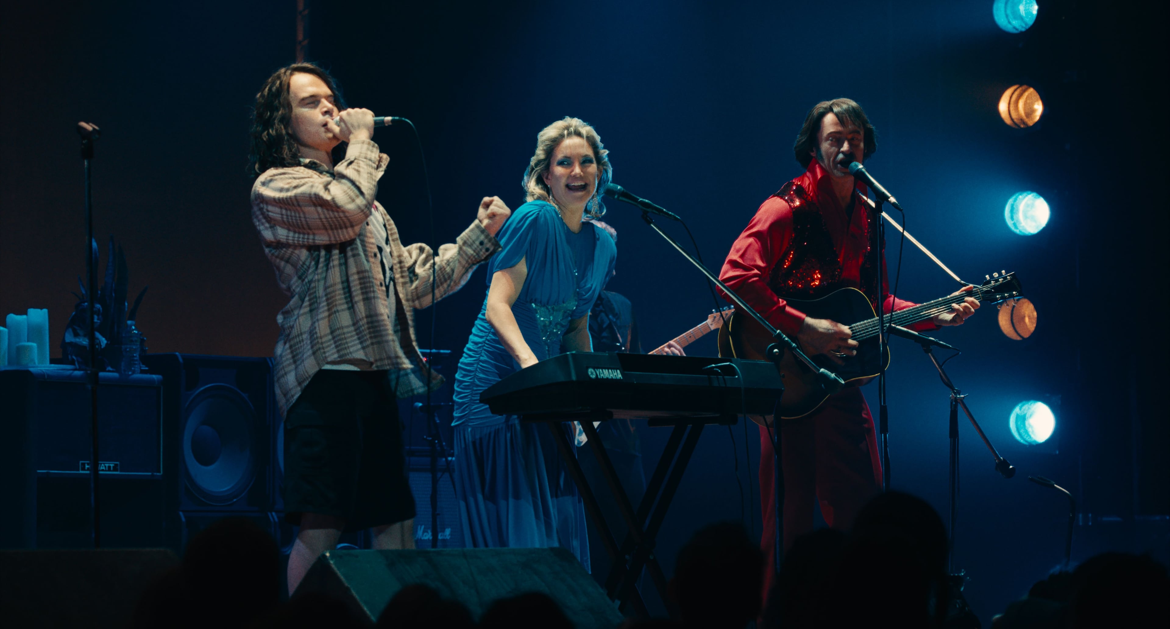 Actor John Beckwith as Eddie Vedder, plays on stage with Kate Hudson and Hugh Jackman in a still from Song Sung Blue. 