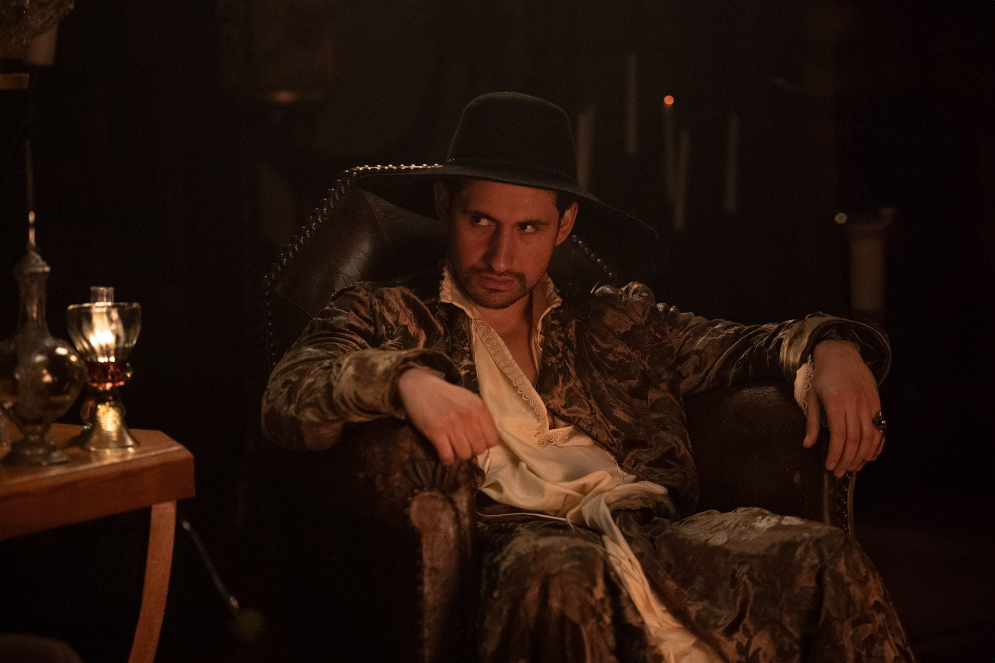 Amir El-Masry sits slouched in a chair in "100 Nights of Hero."