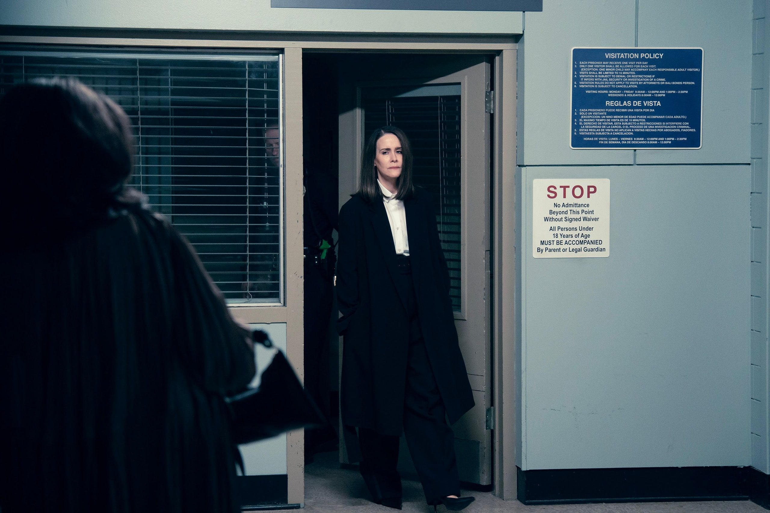 Actor Sarah Paulsin walks into a clinic-like room in a still from All's Fair.