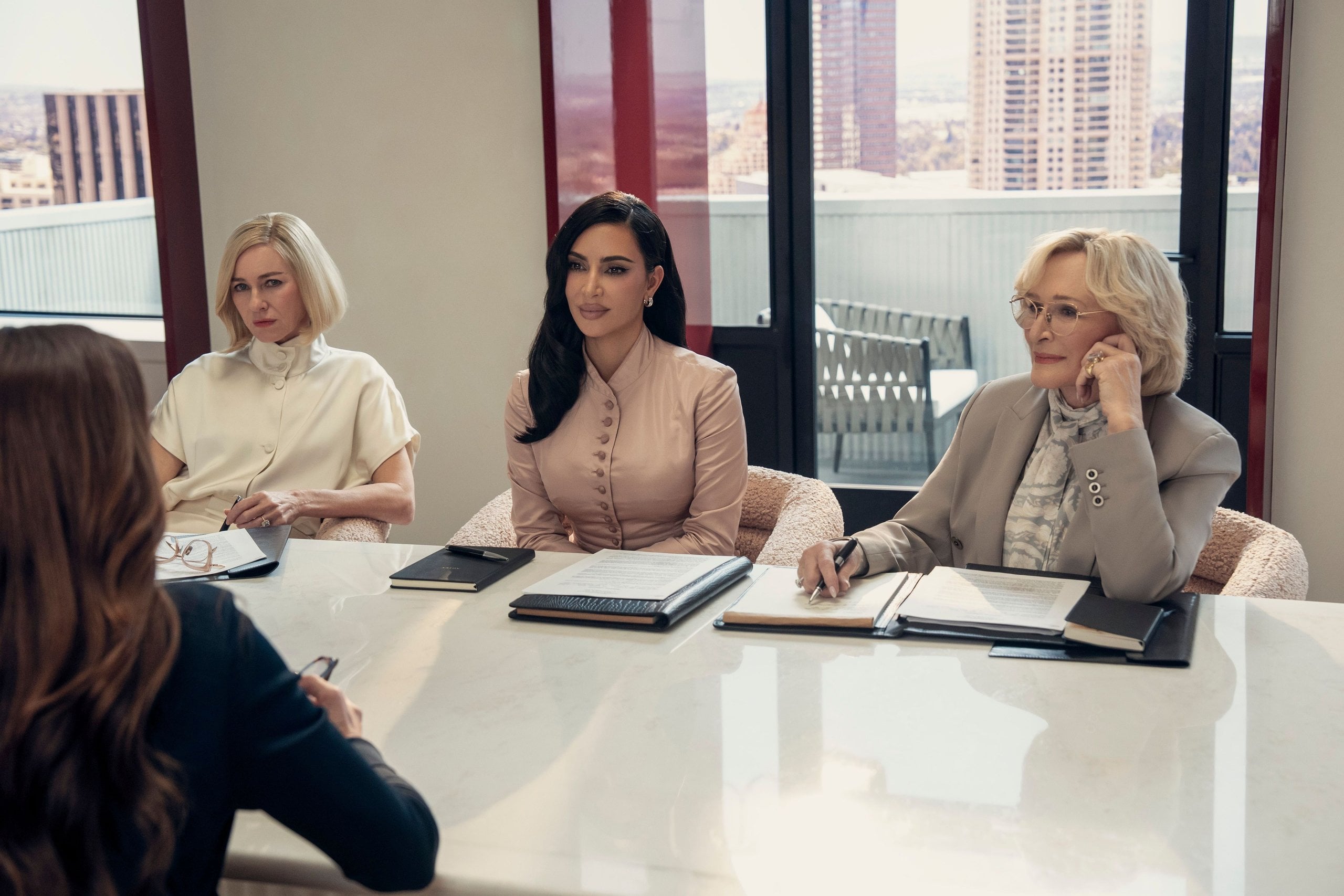 Naomi Watts, Kim Kardashian, and Glenn Close sit at an office table across from a client in a still from All's Fair.