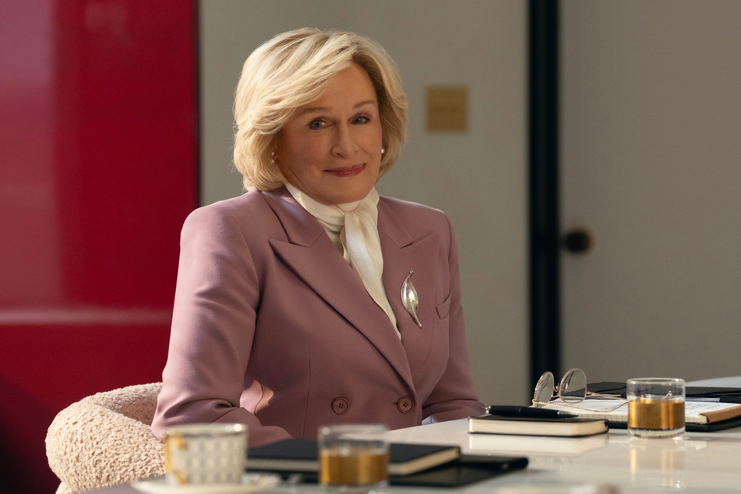 Glenn Close sits at a desk with papers in front of her in a still from All's Fair.
