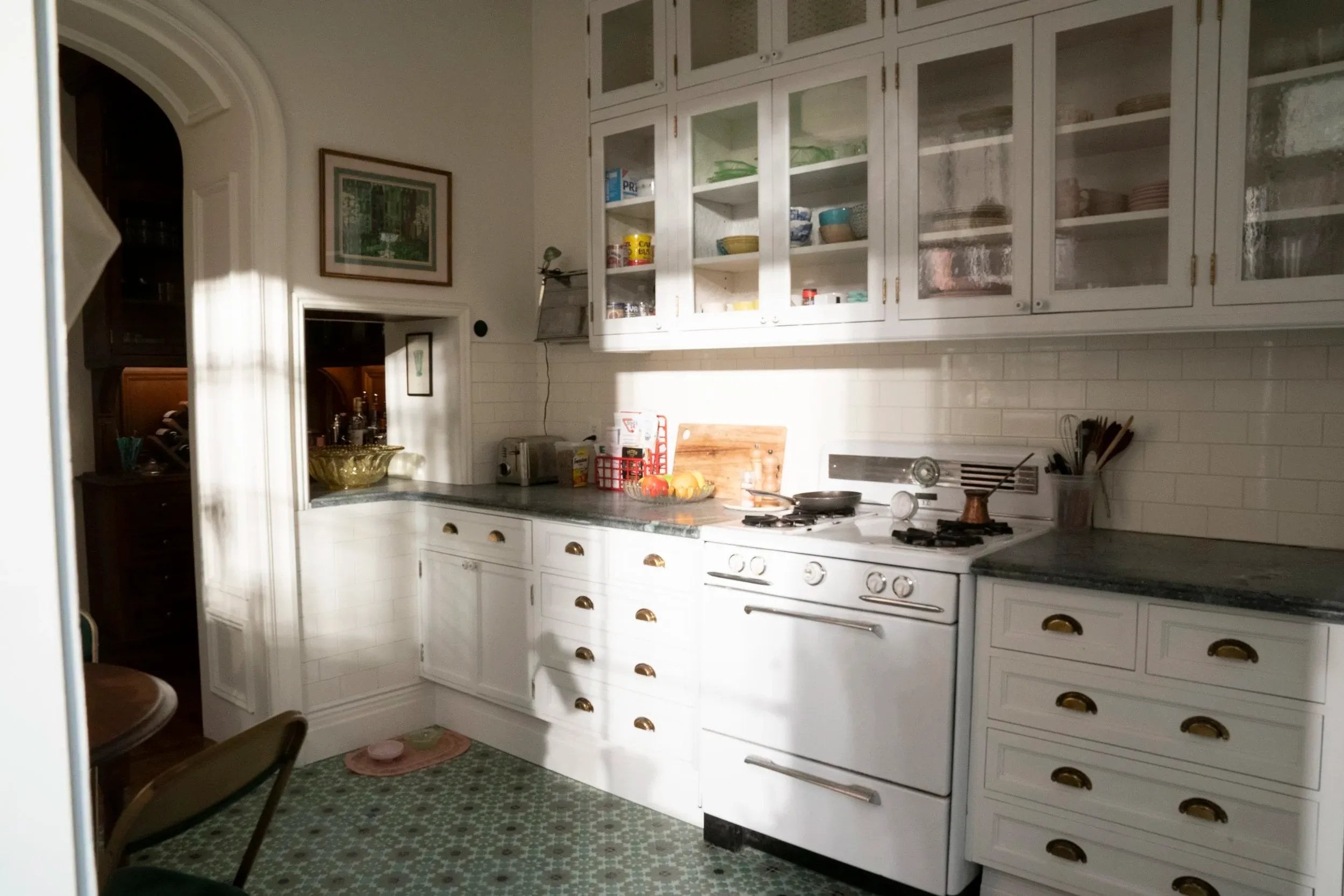 A photo of a kitchen with all white cabinetry, from the HBO series "And Just Like That"