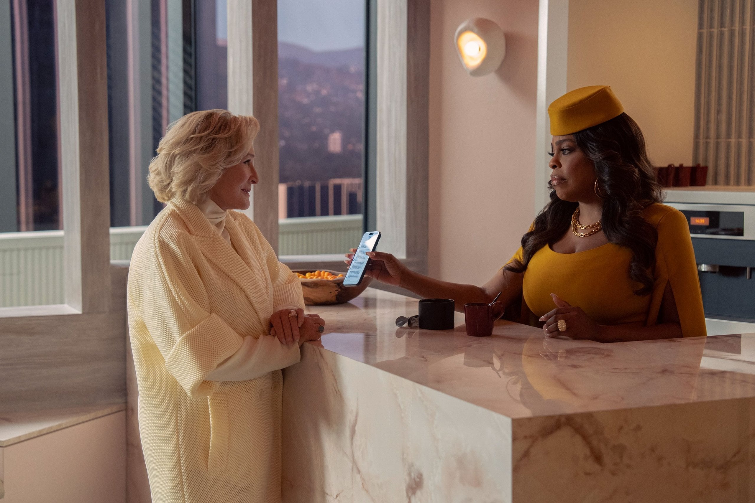 Actors Glenn Close and Niecy Nash stand across from each other at a marble counter in a still from "All's Fair."