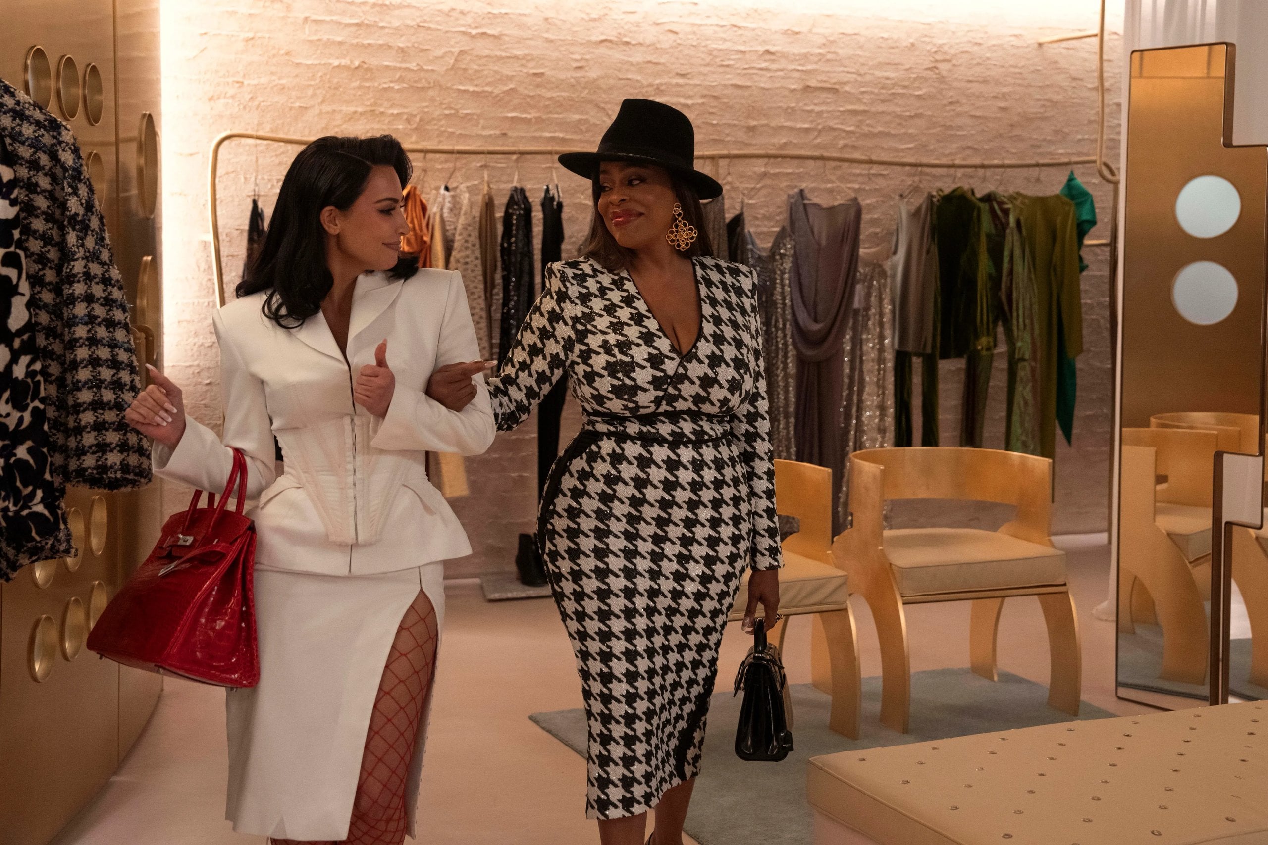 Kim Kardashian and Niecy Nash walk arm-in-arm in a fancy clothing store in a still from Hulu's All's Fair.