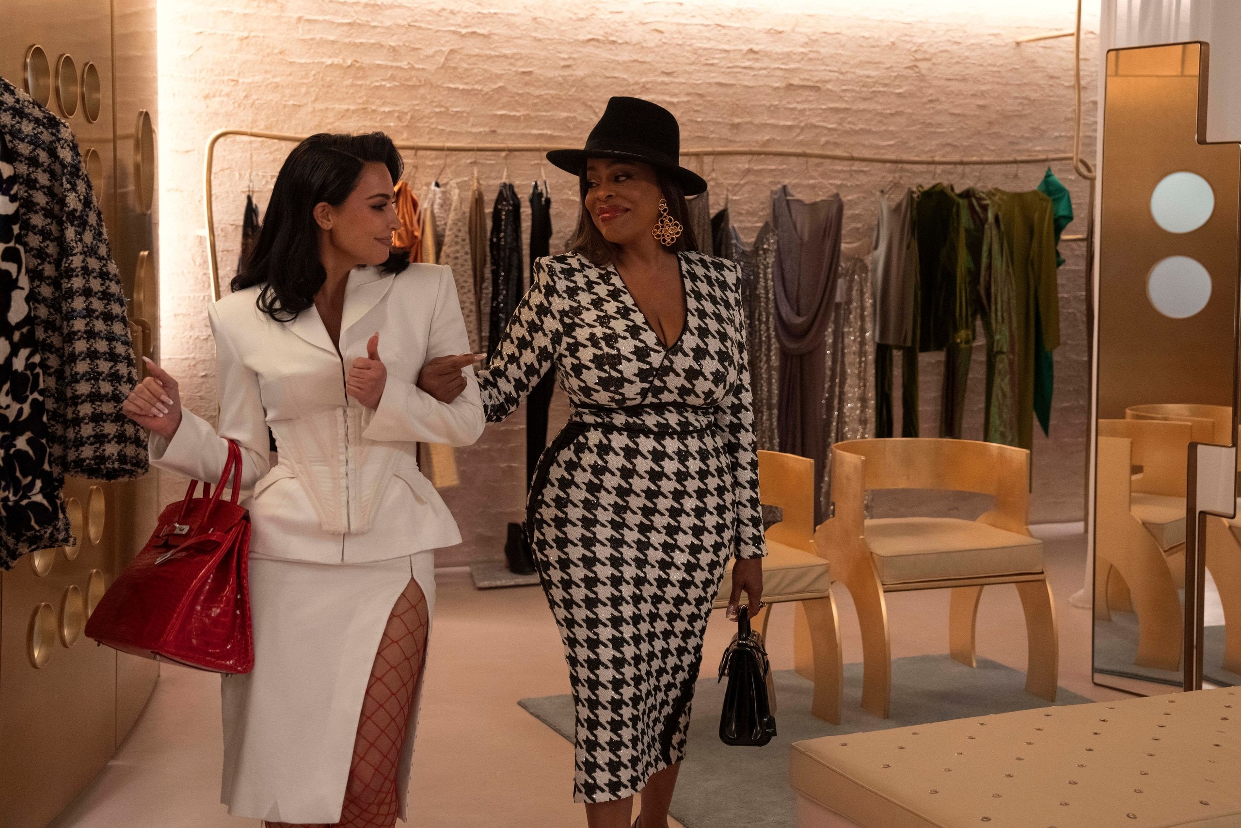 Kim Kardashian and Niecy Nash walk arm-in-arm in a fancy clothing store in a still from Hulu's All's Fair.
