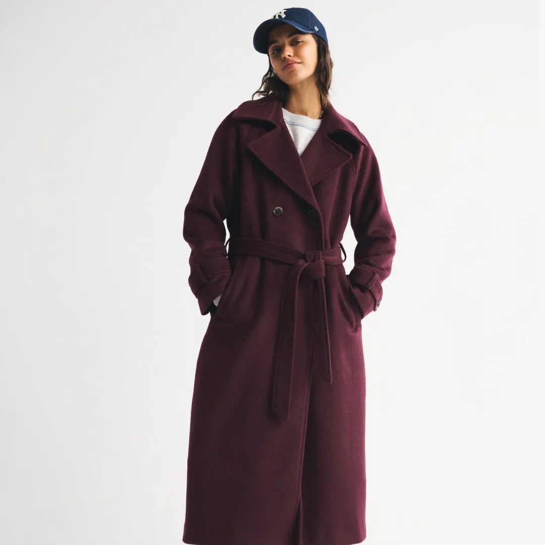 A model wears the Abercrombie & Fitch Carrie Wool-Blend Trench Coat in a burgundy color