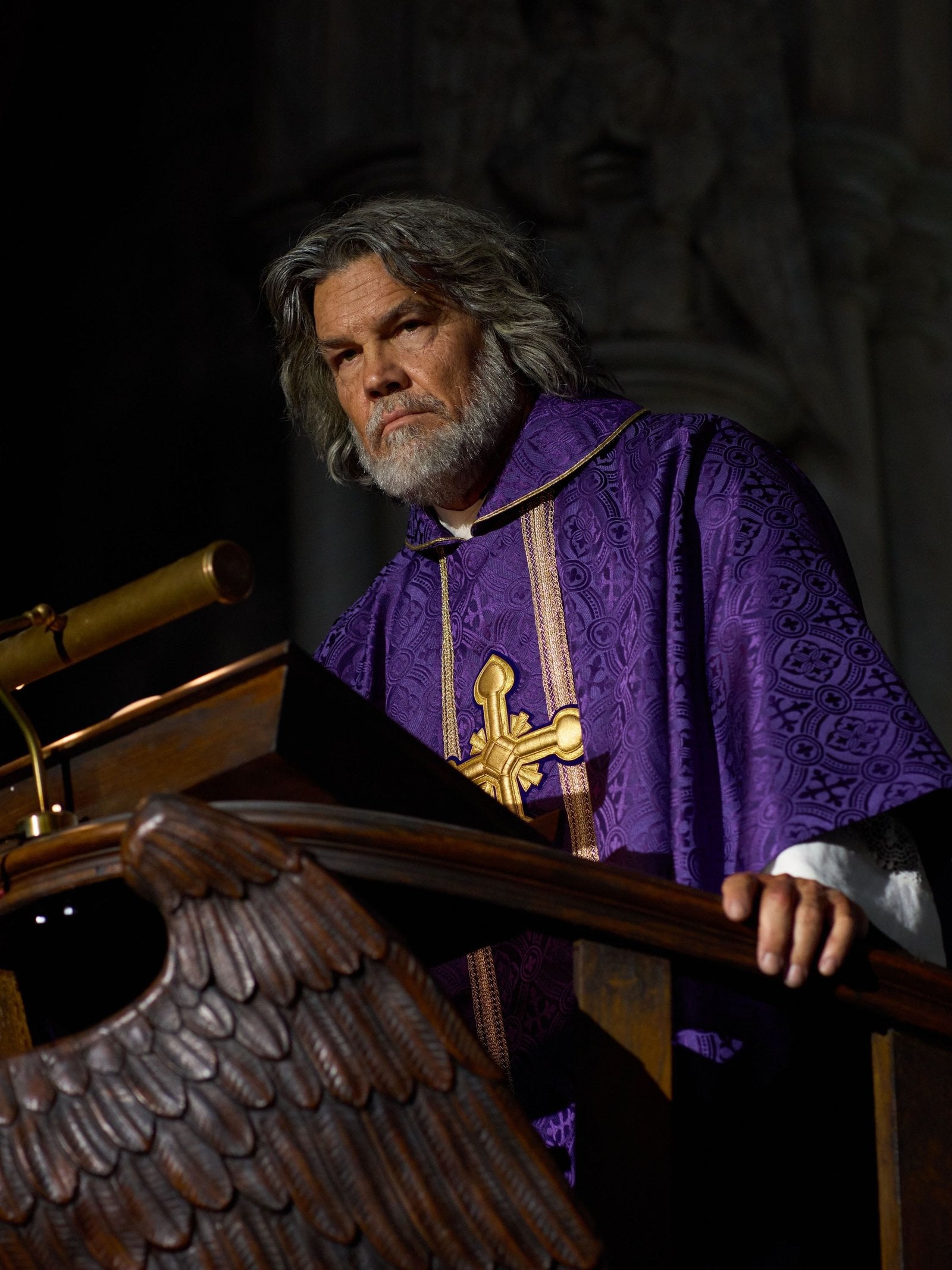 Actor Josh Brolin stands at the altar in a purple ferraiolo in "Wake Up Dead Man: A Knives Out Mystery."