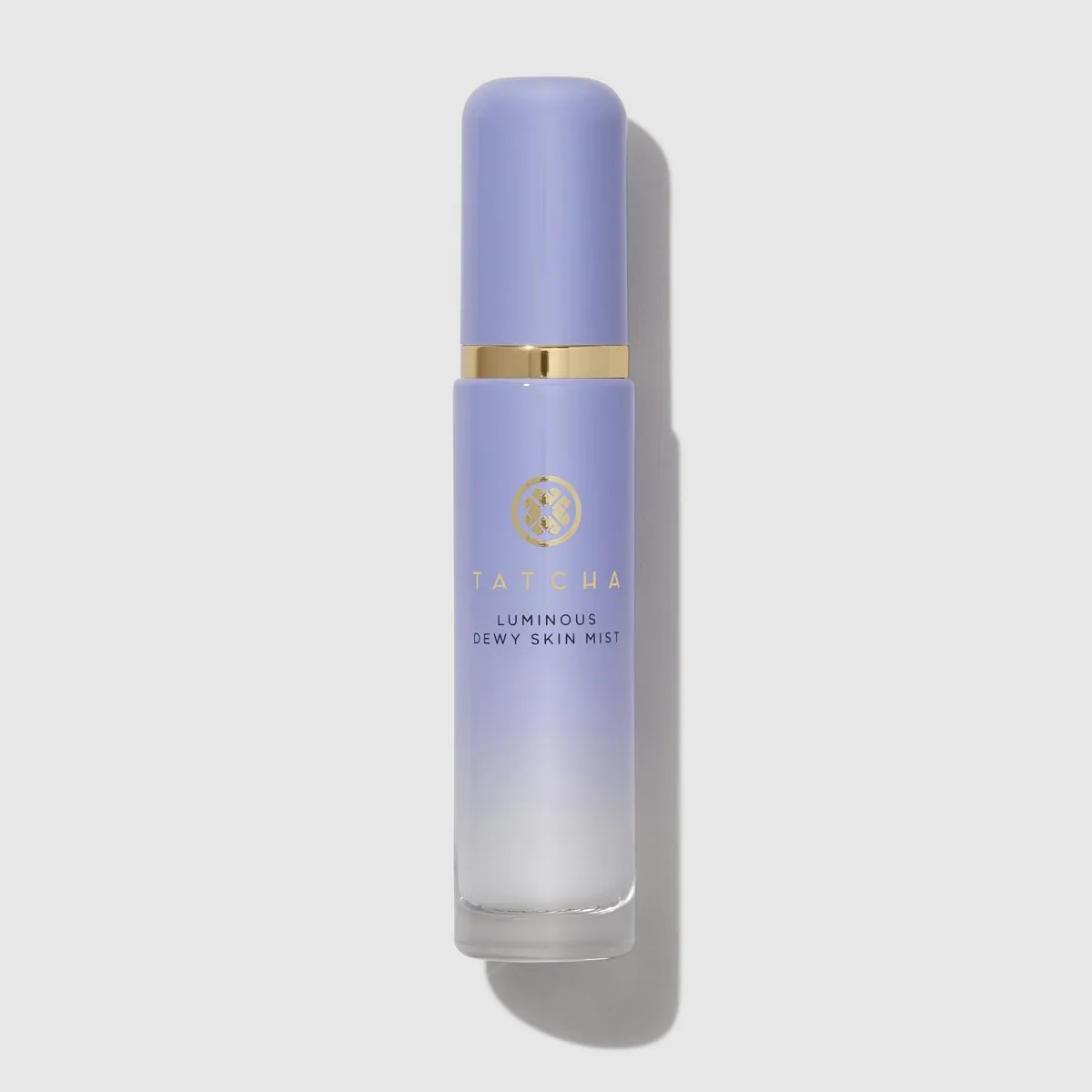A closed bottle of the Tatcha Luminous Dewy Skin Mist against a pale gray background