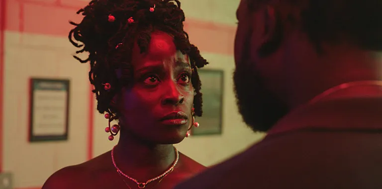 A close up of actor Babirye Bukilwa staring at someone intensely in a scene from "Dreaming Whilst Black."