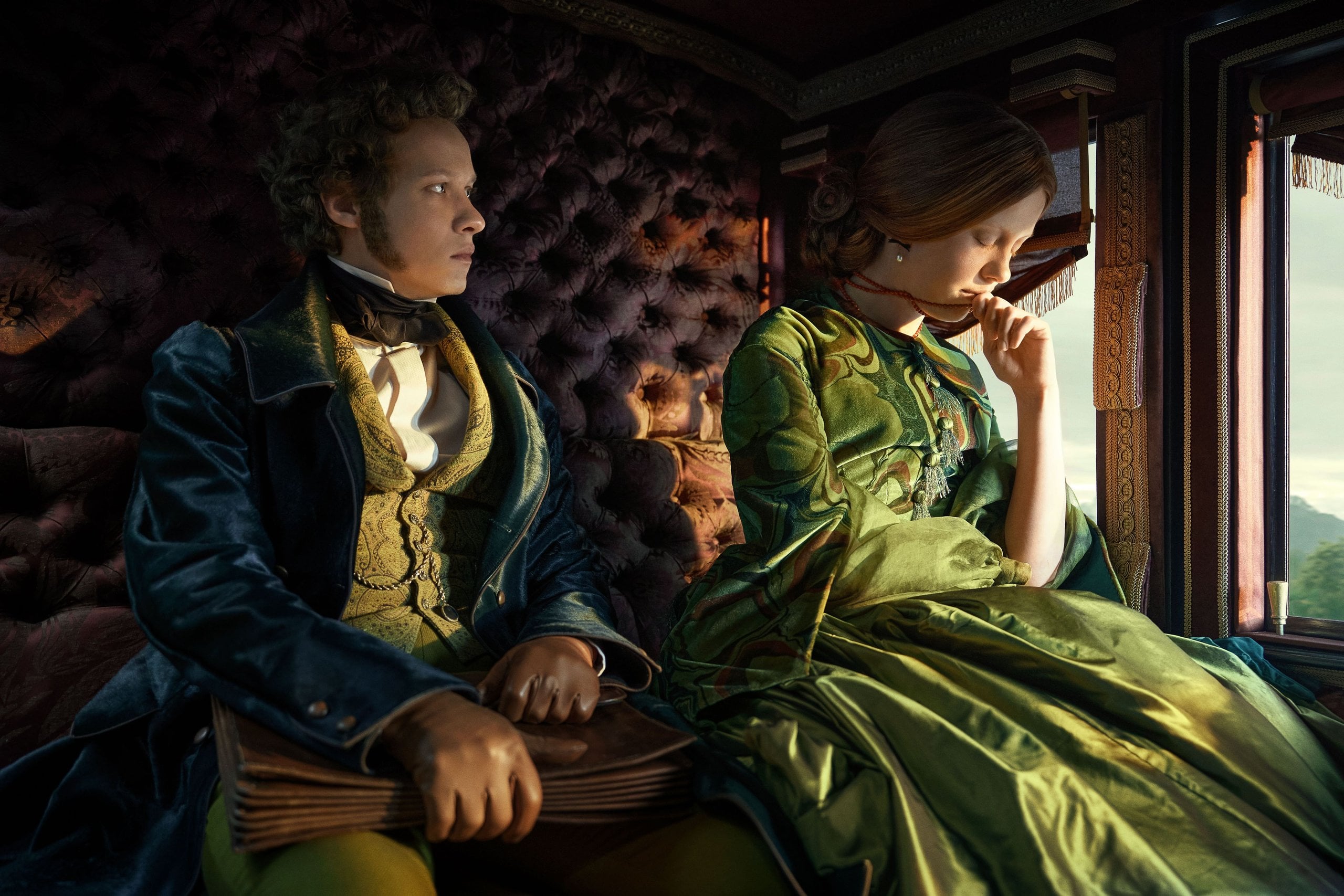 Actors Felix Kammerer and Mia Goth sit in the back of a sunny horse-drawn carriage in a still from Frankenstein.