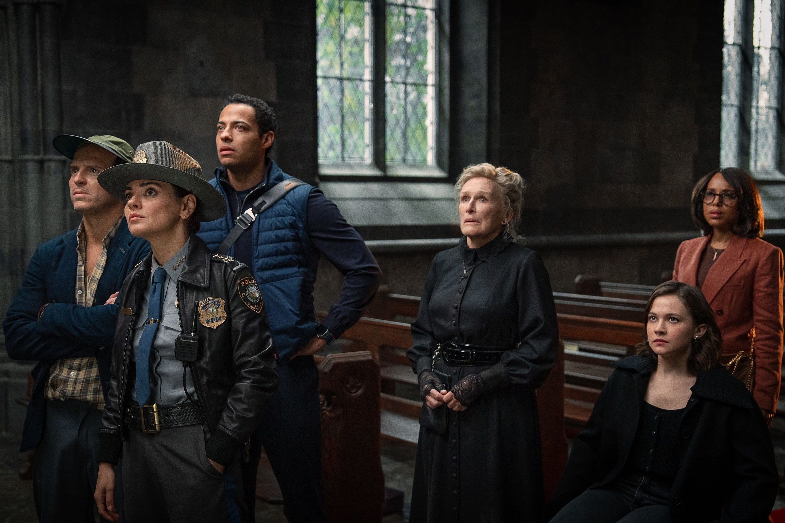 Actor Glenn Close stands beside police officers in a church.