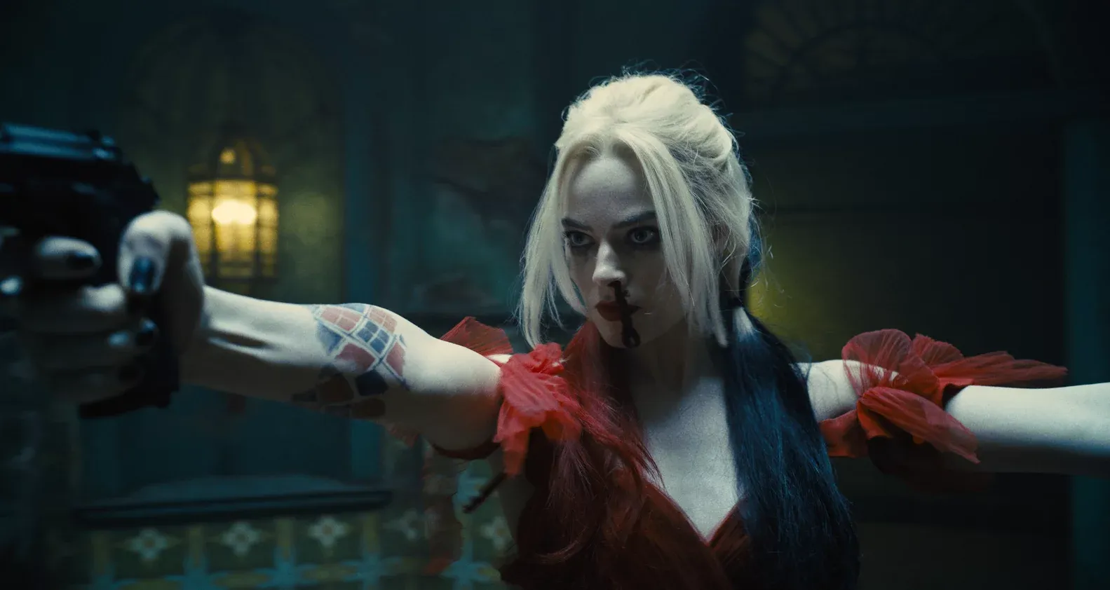 Margot Robbie as Harley Quinn, standing holding a gun in front of her, in the The Suicide Squad