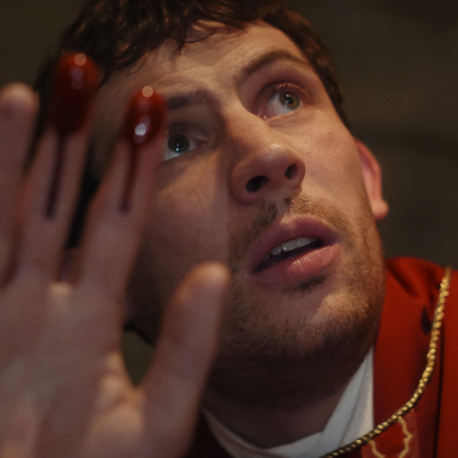 A closeup of actor Josh O'Connor with blood on his hands in "Wake Up Dead Man: A Knives Out Mystery."