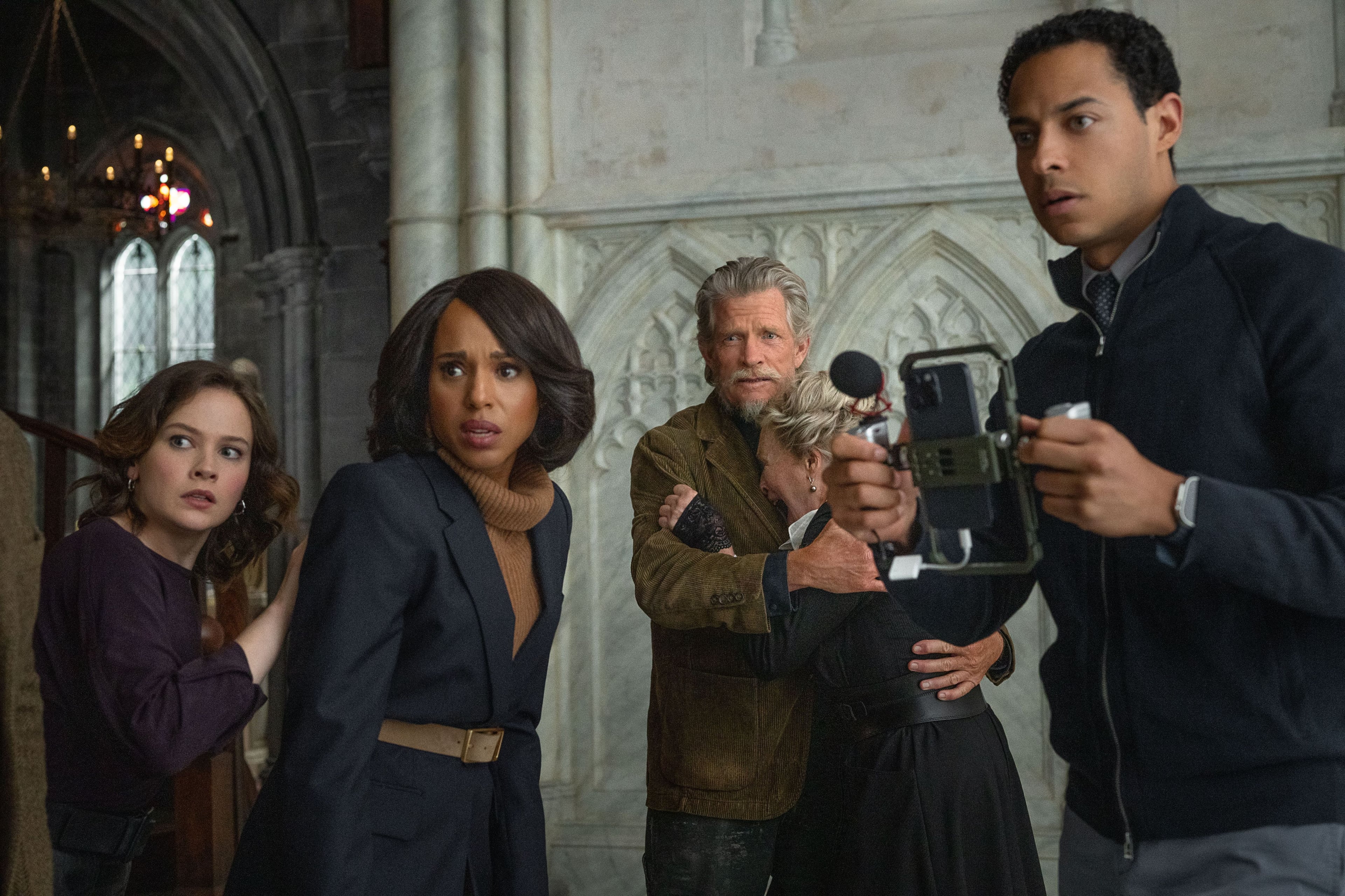 Four cast members of "Wake Up Dead Man: A Knives Out Mystery" stand alert in a church.