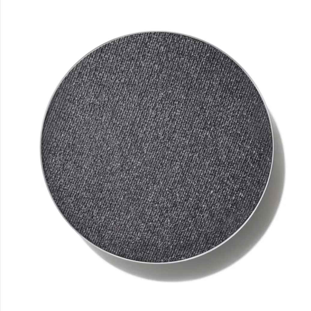 A pan of MAC Eye Shadow in Glitch in the Matrix, a sparkly gray color, against a white background