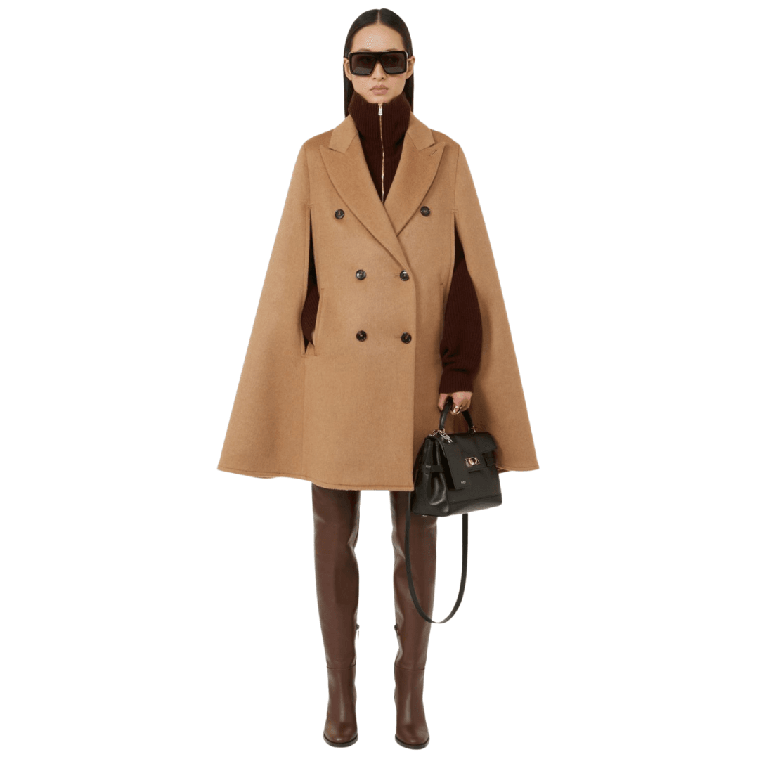A model wears the Max Mara Camel drap cape with tall boots