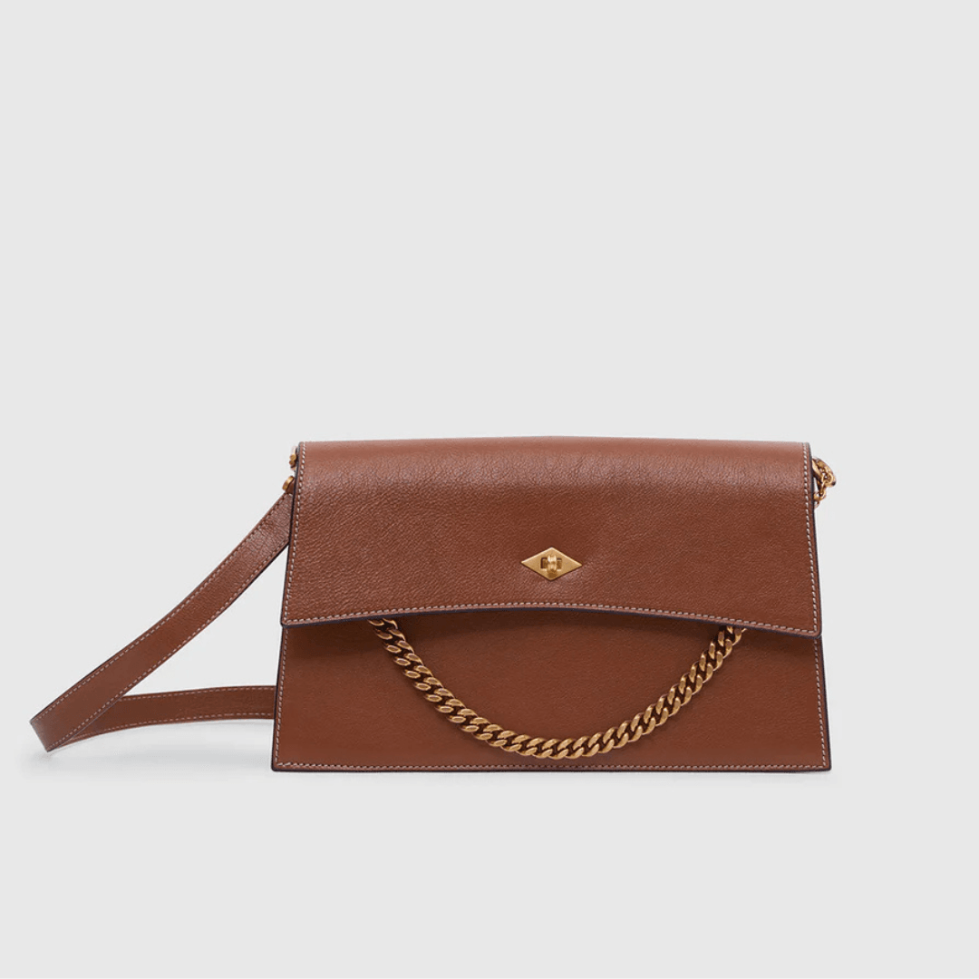 The Métier Roma Shoulder Bag in Cognac against a gray background