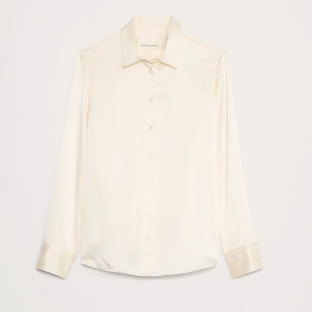 White silk blouse against a pale gray background