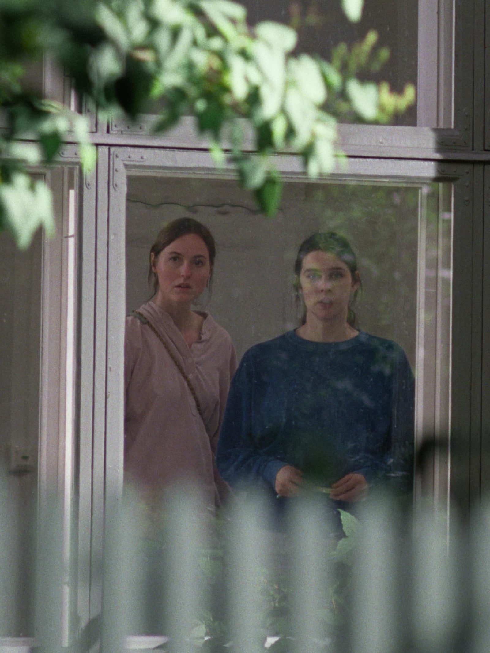Renate Reinsve and Inga Ibsdotter Lilleaas looking out of a window in "Sentimental Value."