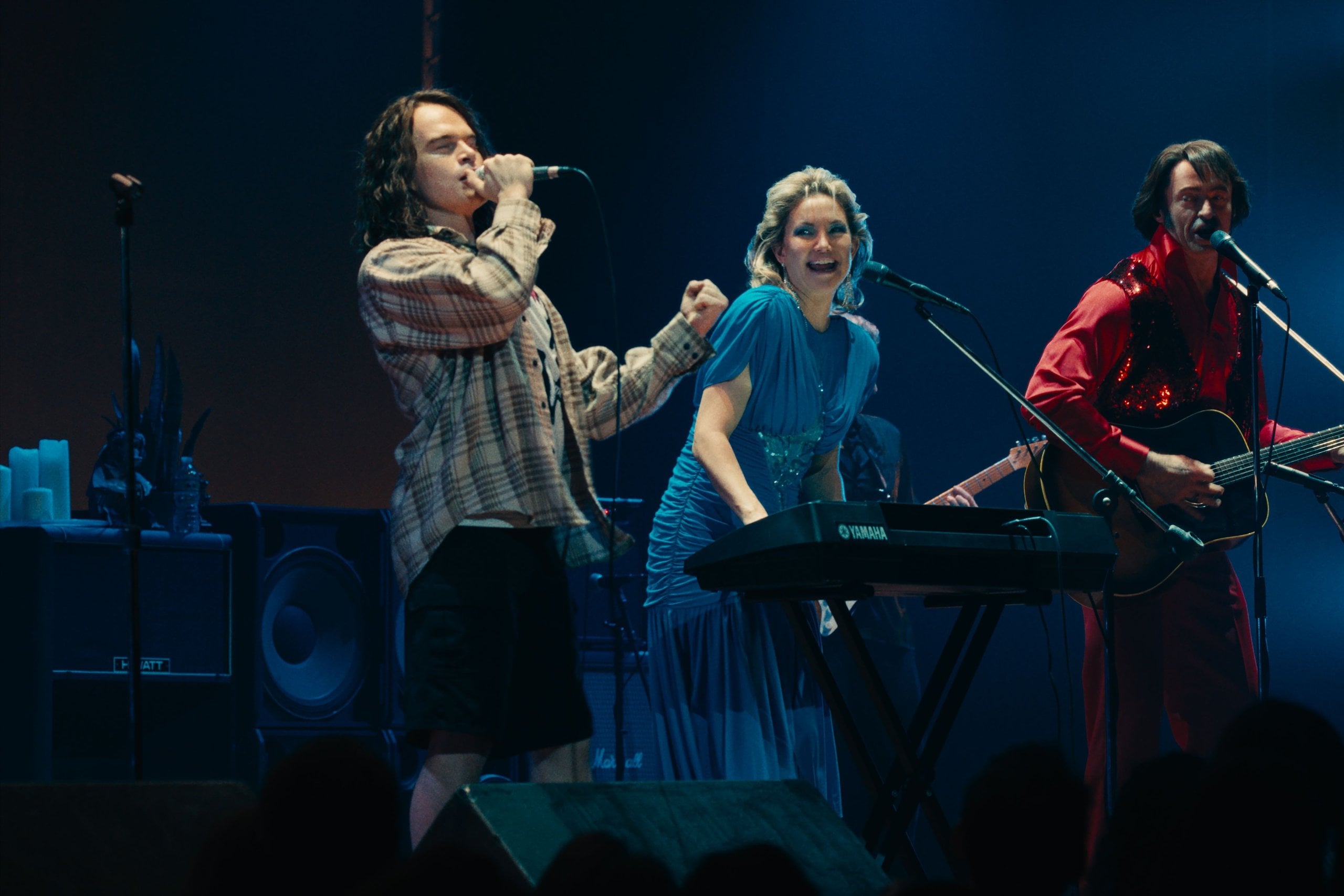 Actor John Beckwith as Eddie Vedder, plays on stage with Kate Hudson and Hugh Jackman in a still from Song Sung Blue.