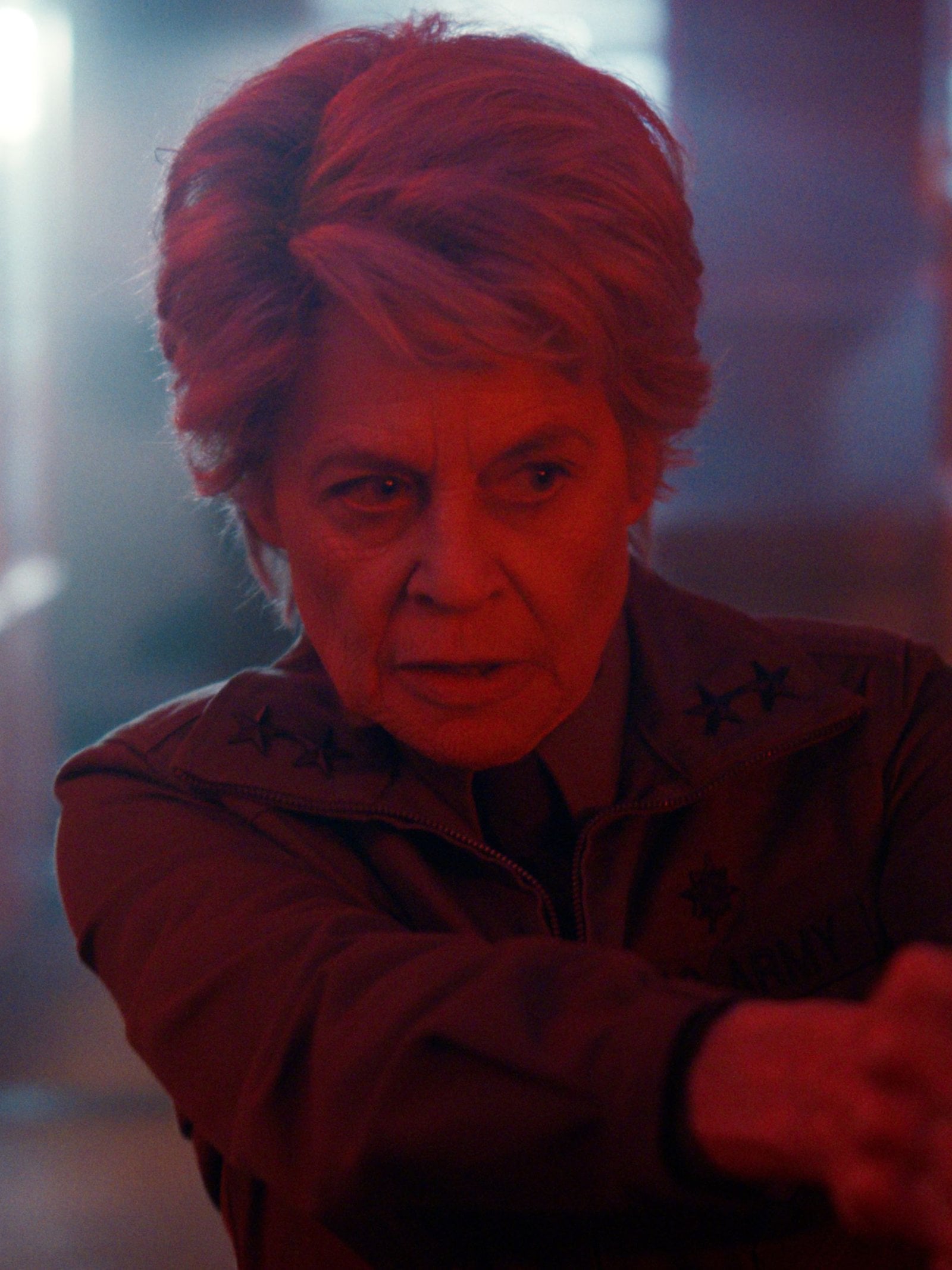 Actress Linda Hamilton as Dr. Kay points a gun in a still from Stranger Things season five.