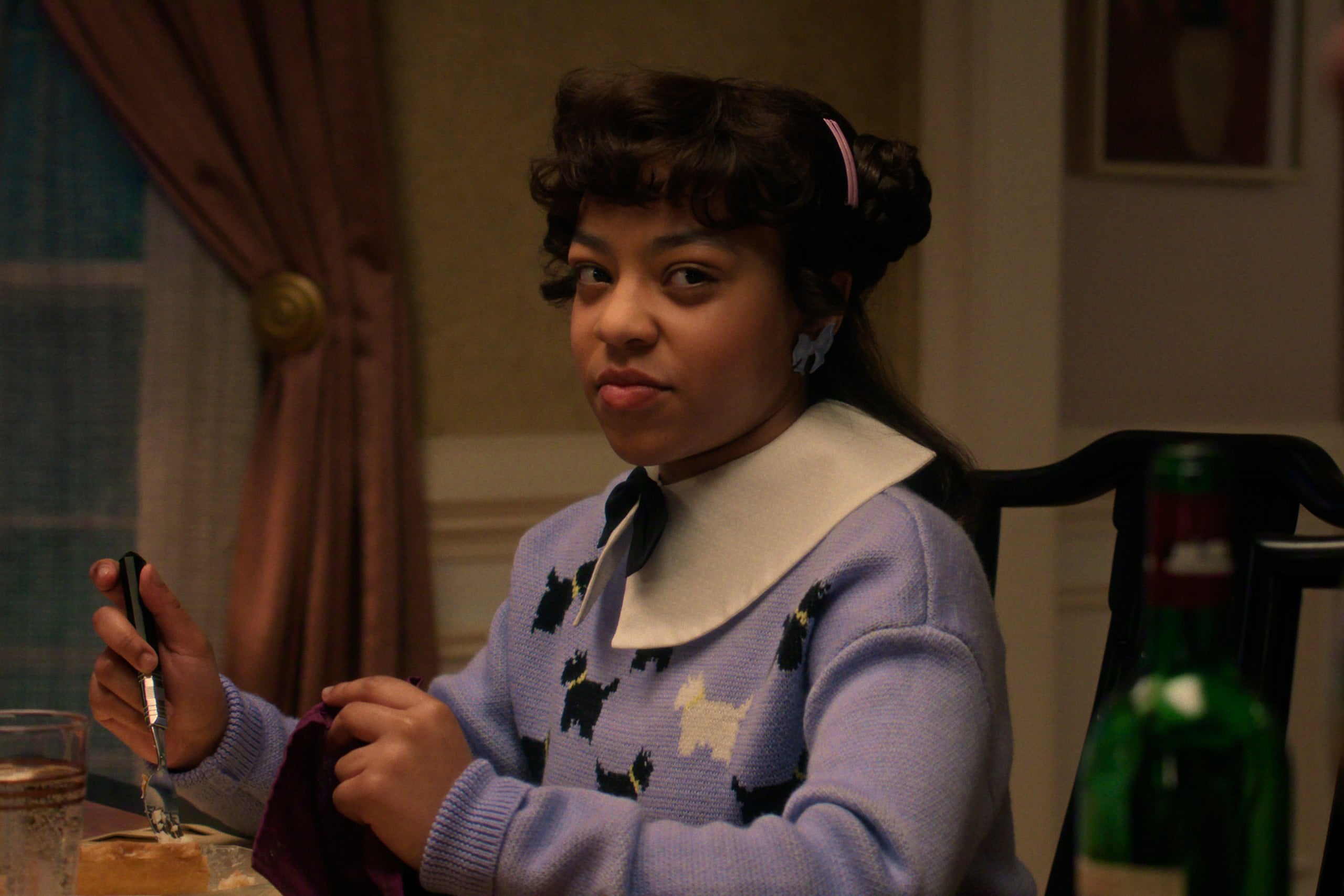 Priah Ferguson as Erica Sinclair sits at the dinner table in "Stranger Things" season five.