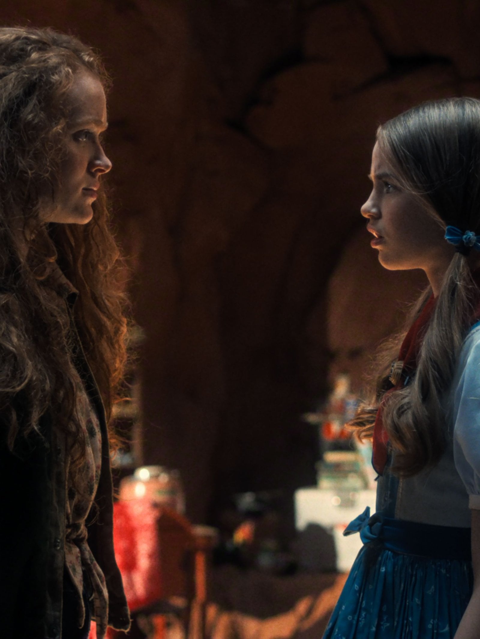Actors Sadie Sink and Nell Fisher stand across from one another in a cave in a still from Stranger Things season five.