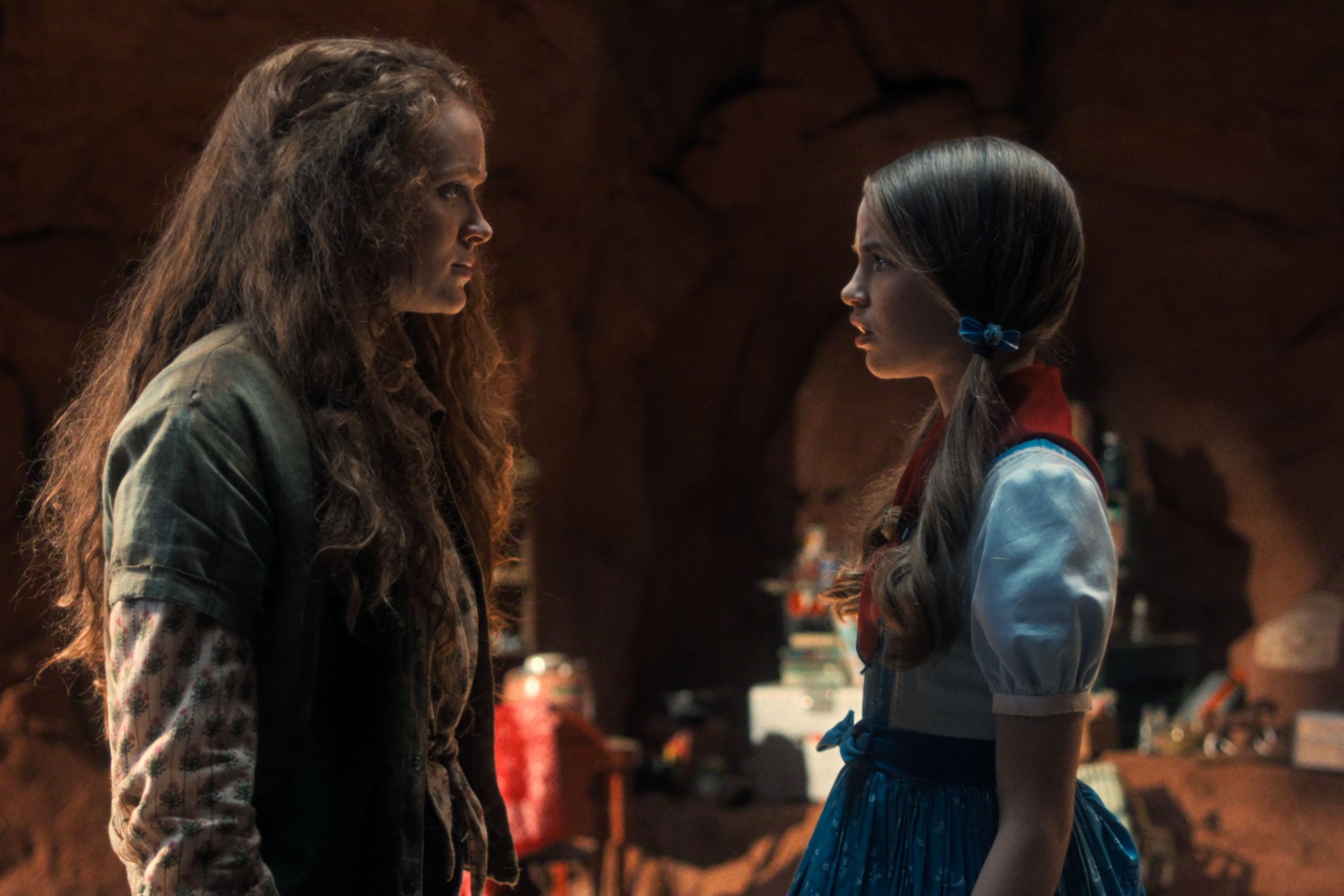 Actors Sadie Sink and Nell Fisher stand across from one another in a cave in a still from Stranger Things season five.