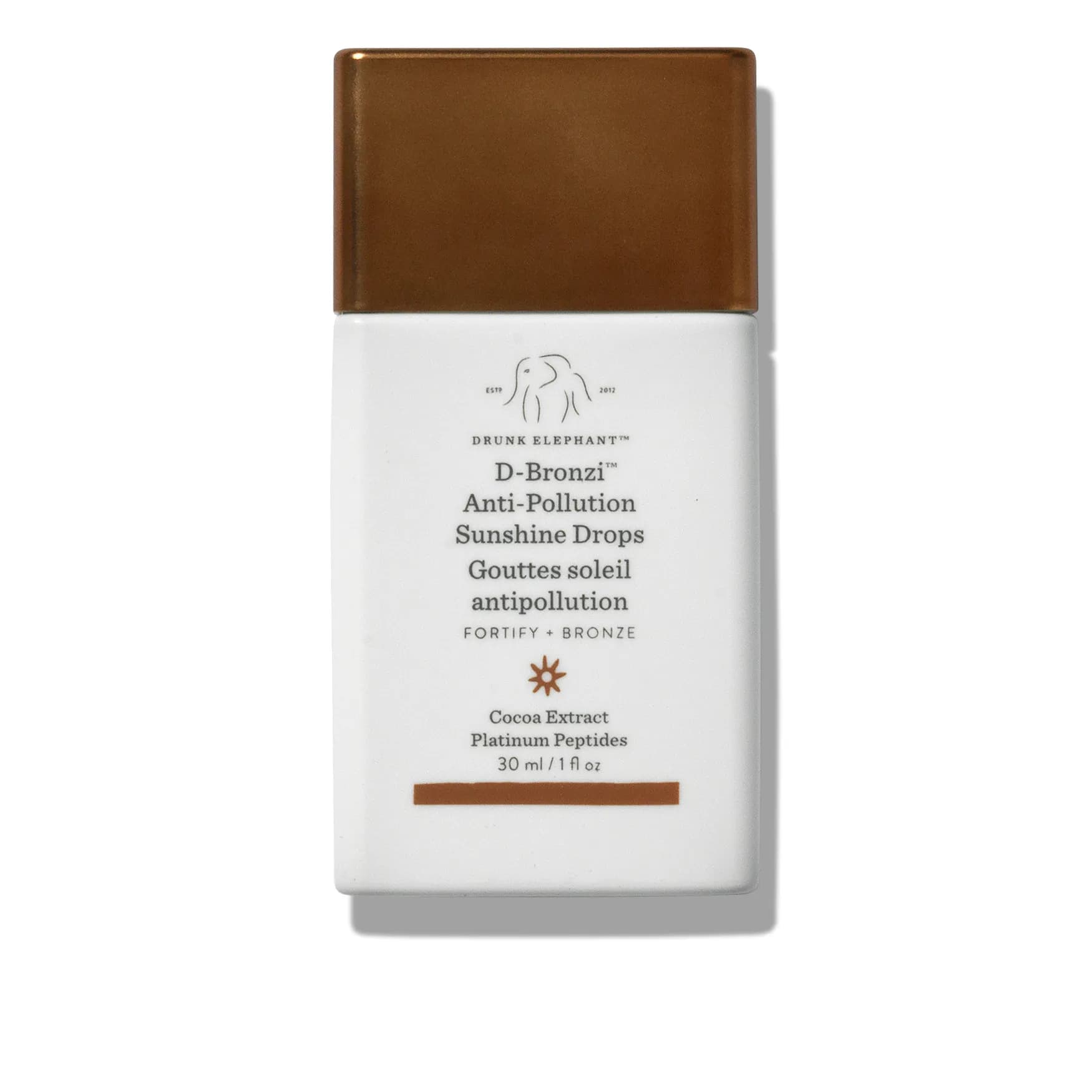 A rectangular shaped bottle of Drunk Elephant bronzing drops—a white bottle with brown cap against white background