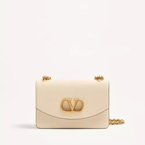 Valentino Garavani Vain Shoulder Bag in a cream color, sits against a white background.