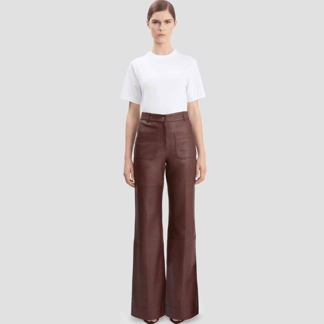 A models wears the Victoria Beckham Leather Alina Trouser In Burgundy and a white top
