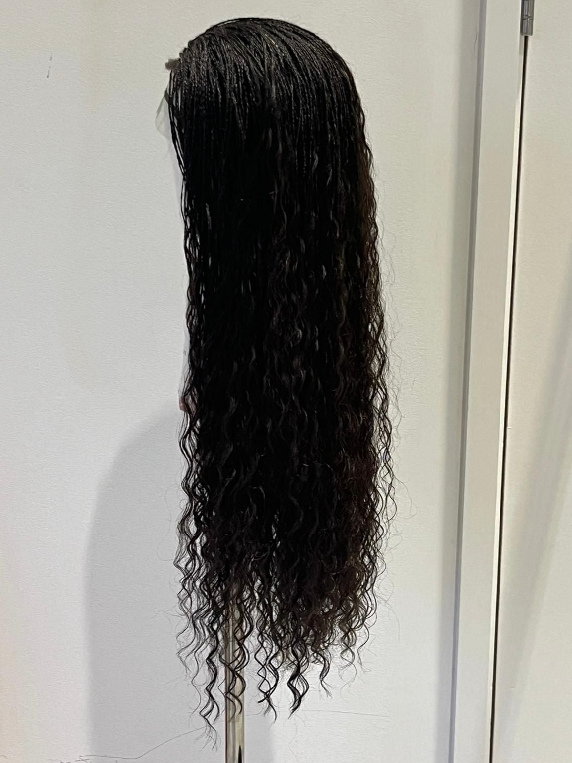 One of Elphaba's micro-braided wigs on a mannequin head, on the set of Wicked: For Good.