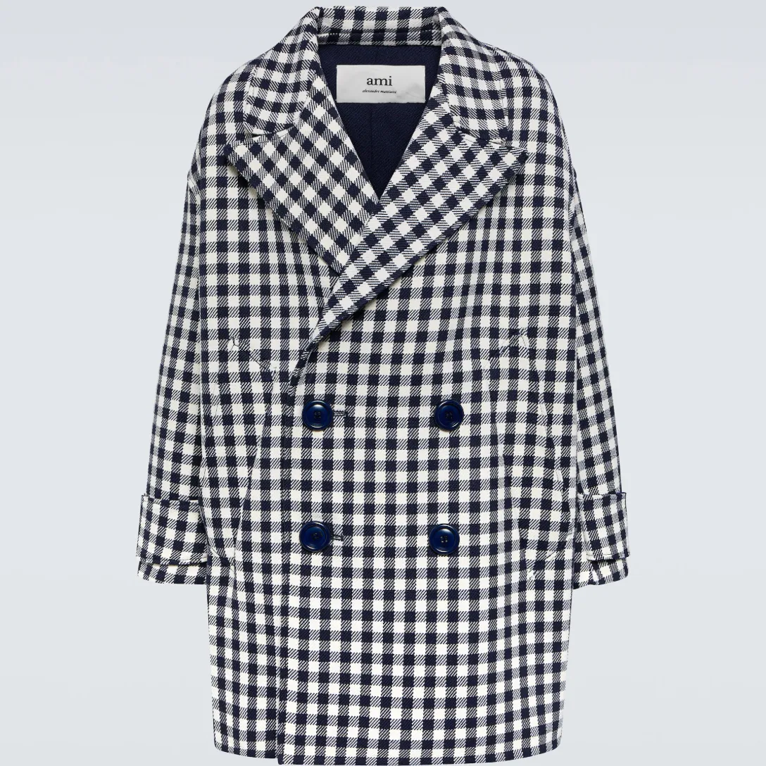 An oversized black-and-white houndstooth coat from Ami Paris against a gray background