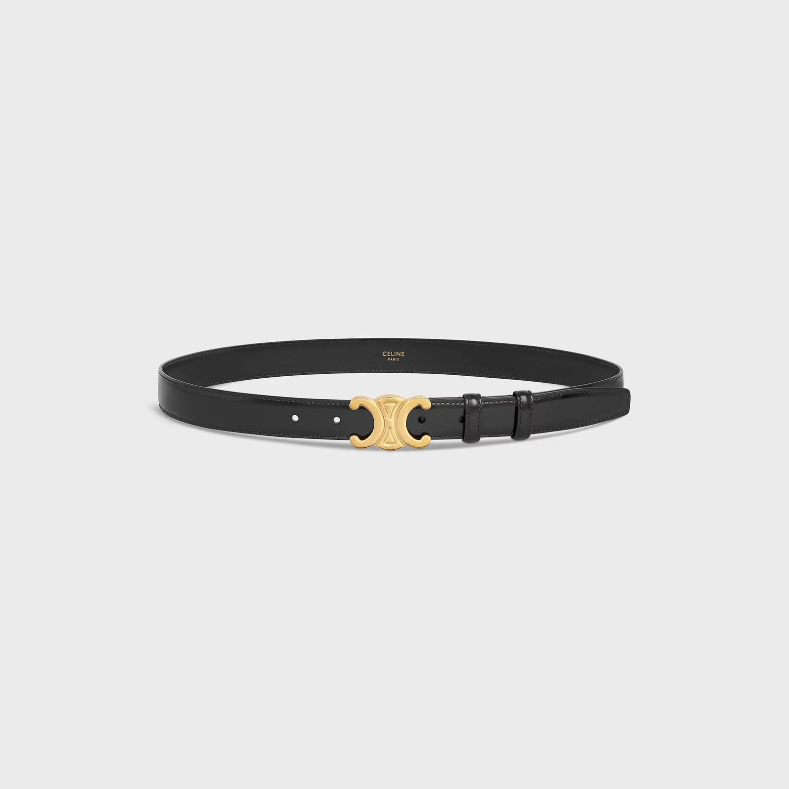 The Celine Triomphe belt - a black belt with gold clasp, against a gray background