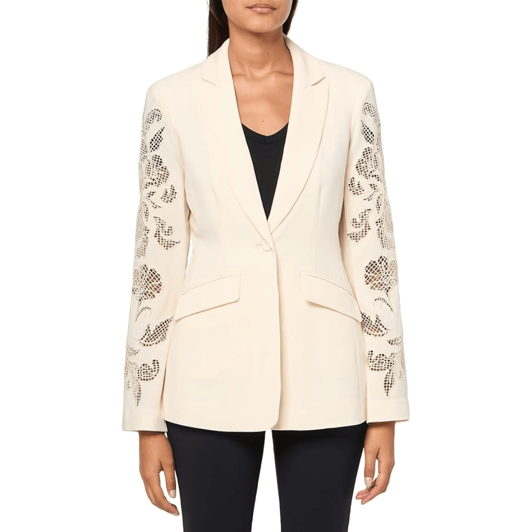 A model wears the white Cinq à Sept Cheyenne Embroidered Blazer with black shirt and leggings