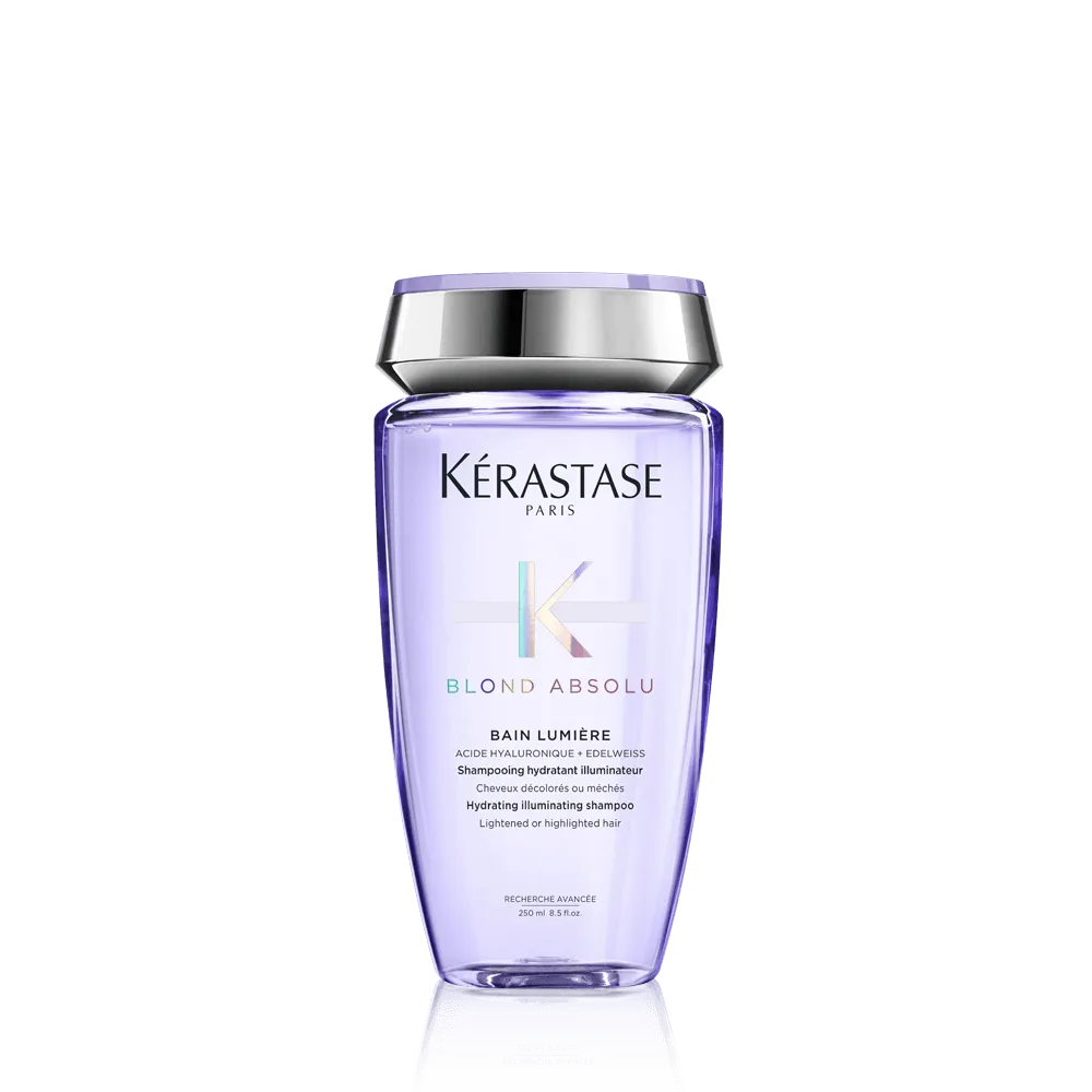 A see-through lilac-colored bottle of Kerastase shampoo against a gray background