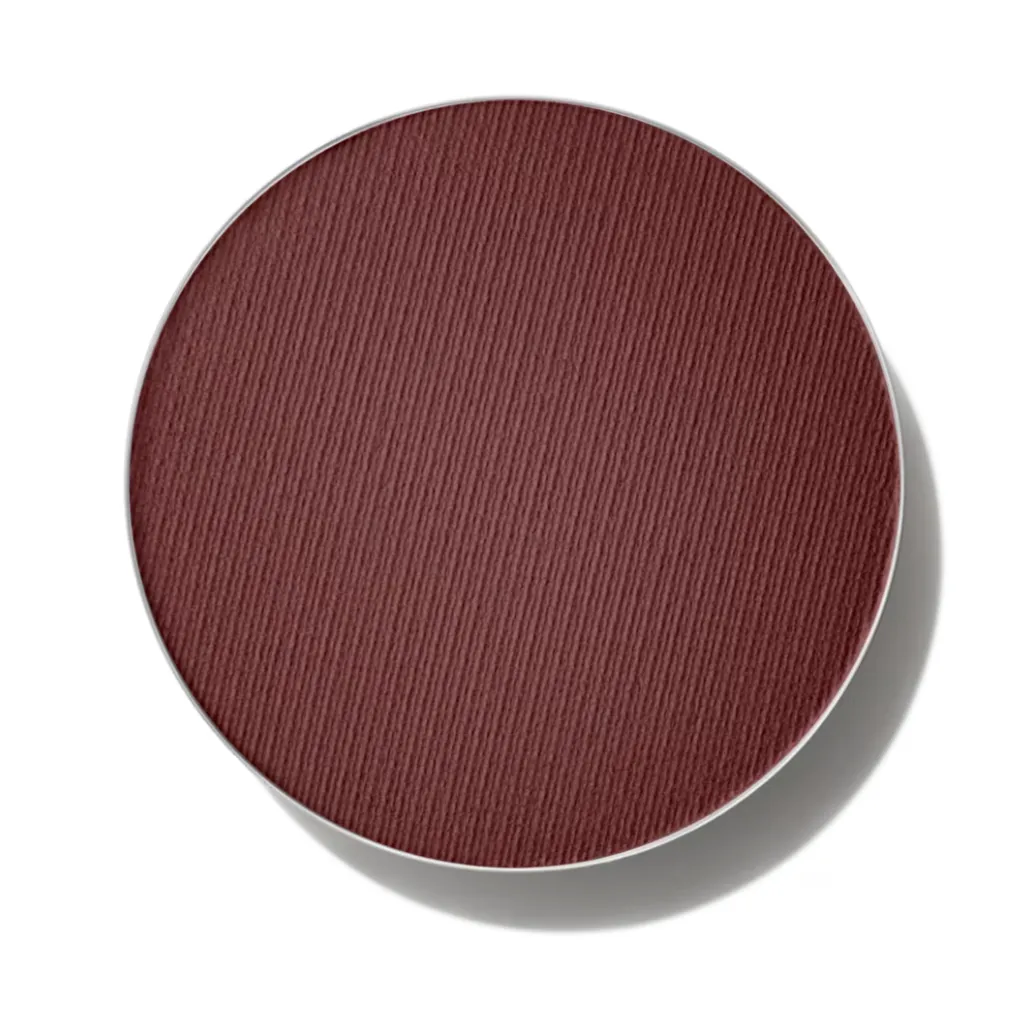 A pan of MAC Eye Shadow in Embark, a reddish brown color, against a white background