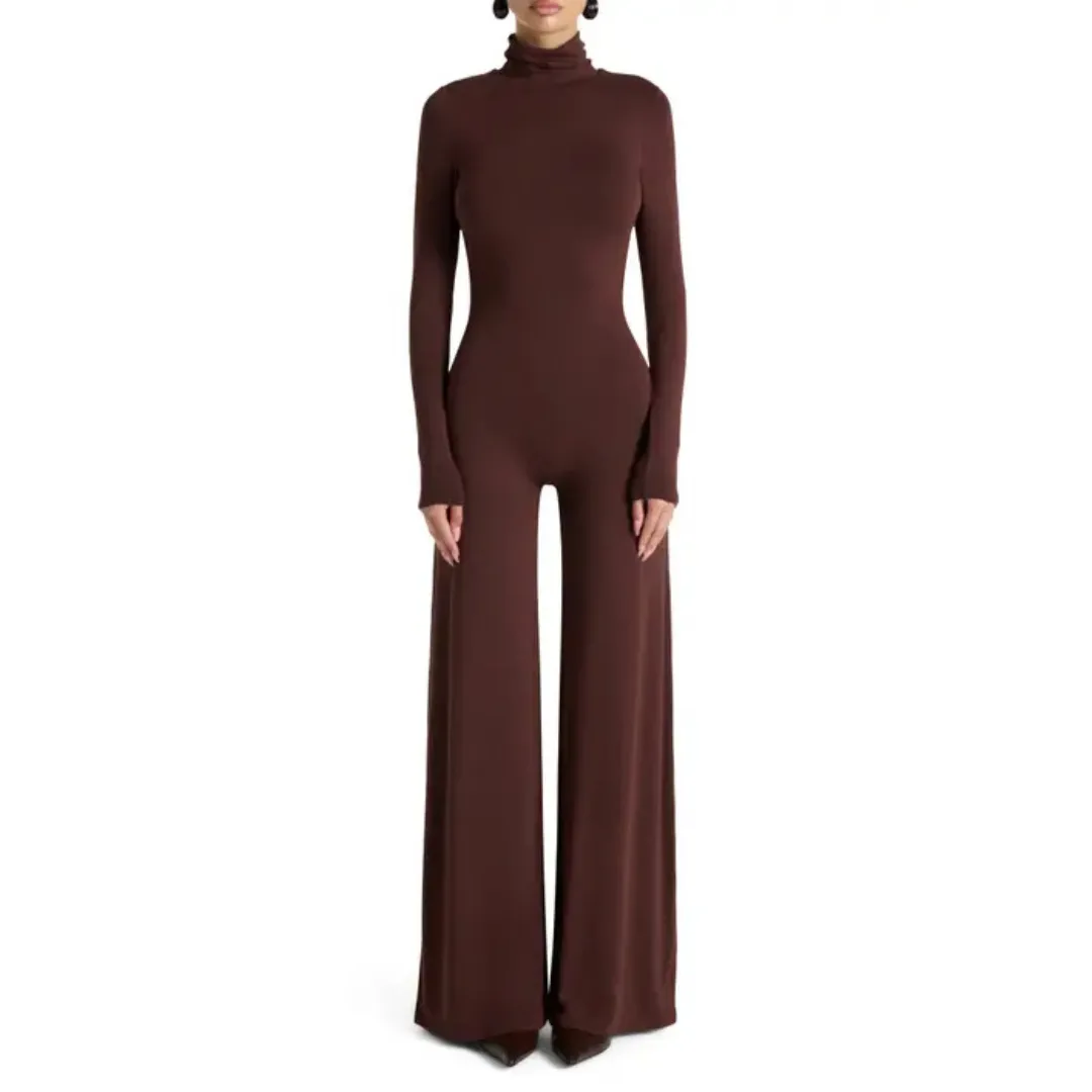 A model wears the Naked Wardrobe Sculpt Turtleneck Wide Leg Jumpsuit in brown against a white background