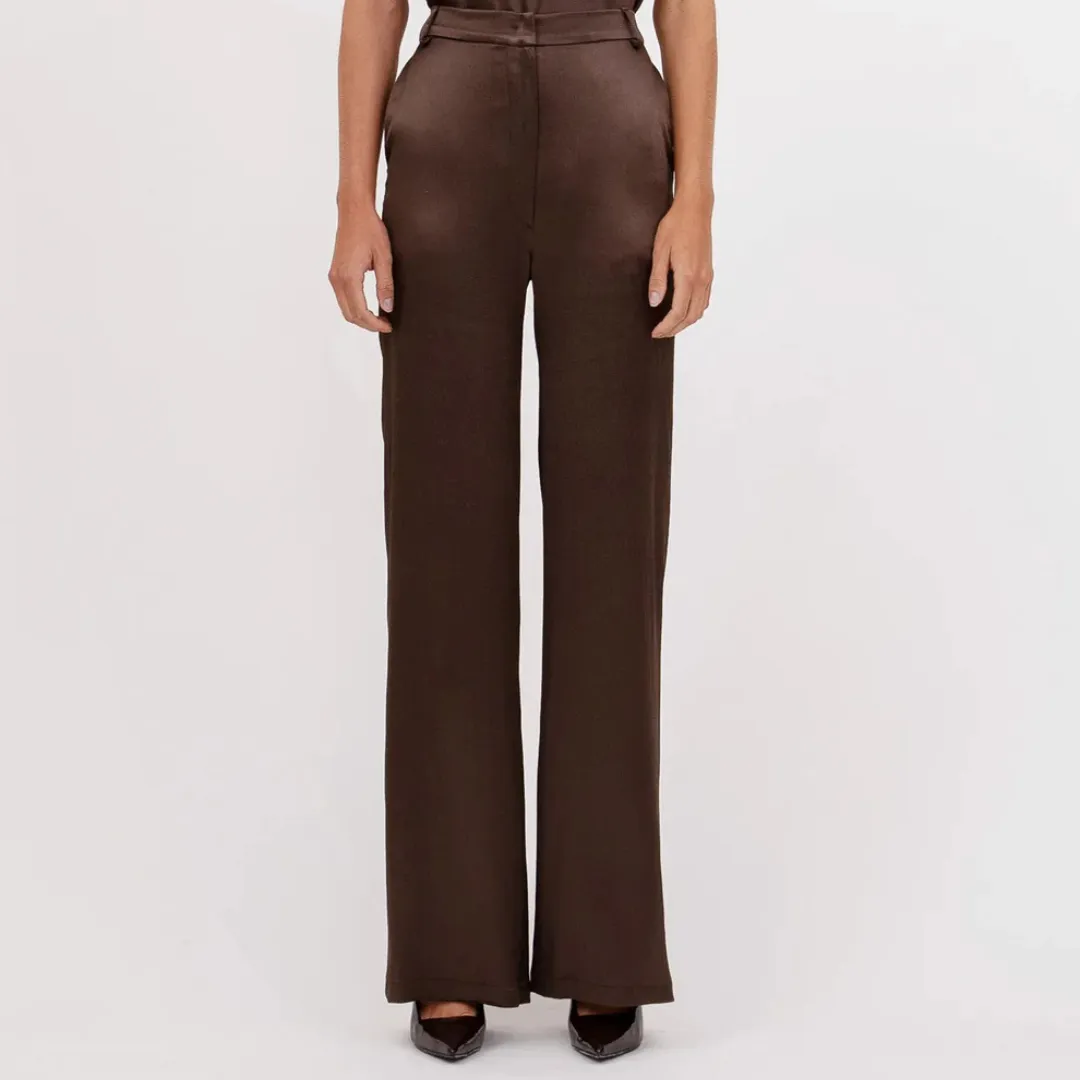 The bottom half of a model wearing silky, chocolate-colored Nonchalant Label Pauline Pant