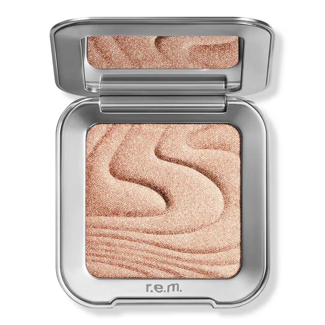 An open compact of r.e.m. Interstellar Highlighter Topper in Miss Mercury against a white background