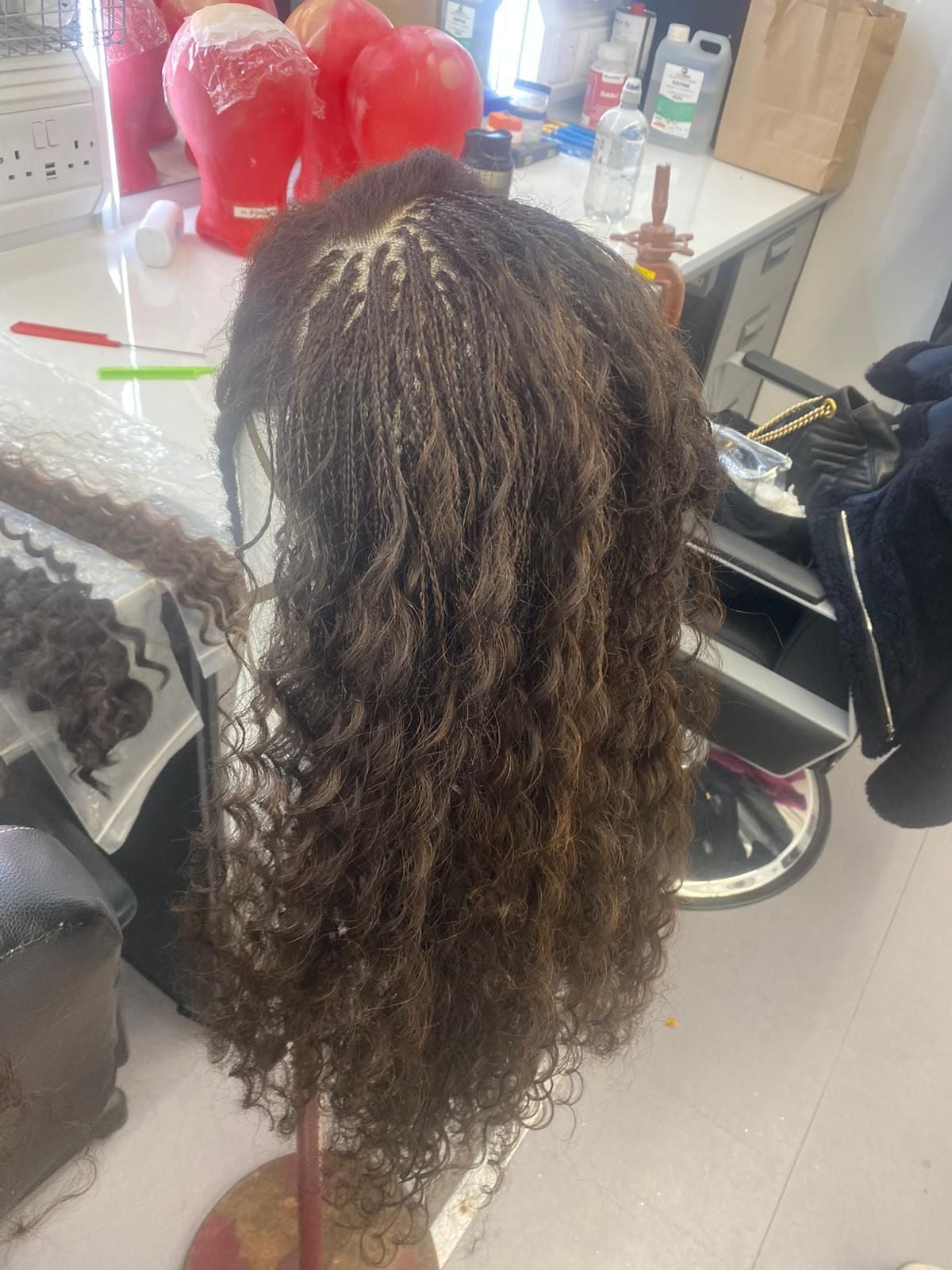A close up of one of Elphaba's wigs during the braiding process for "Wicked: For Good."